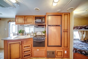 Cocina compacta para autocaravana con estufa, fregadero y microondas.