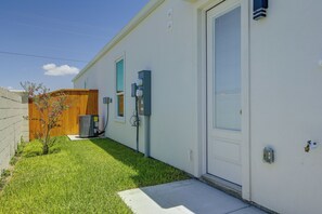 A residential building with a small front yard, a wooden fence, and a single-story structure. - Modern Mcallen Townhome: 4 Mi to Dtwn (McAllen)
