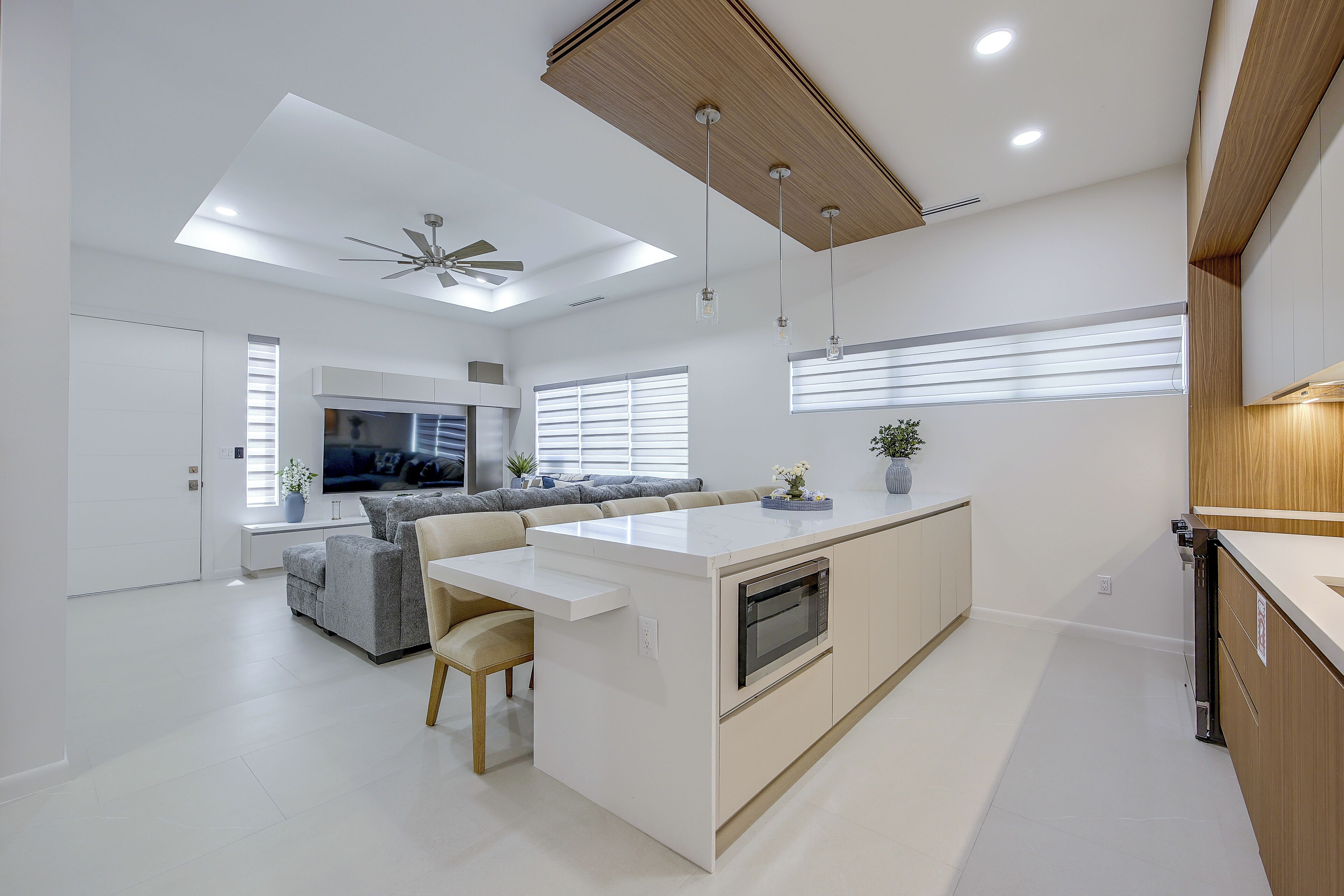 A modern kitchen with a central island, built-in appliances, and pendant lighting.