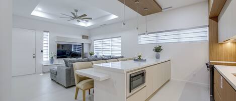 A modern kitchen with a central island, built-in appliances, and pendant lighting.
