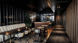 A modern bar area with a long counter, cushioned seating, and a variety of chairs.
