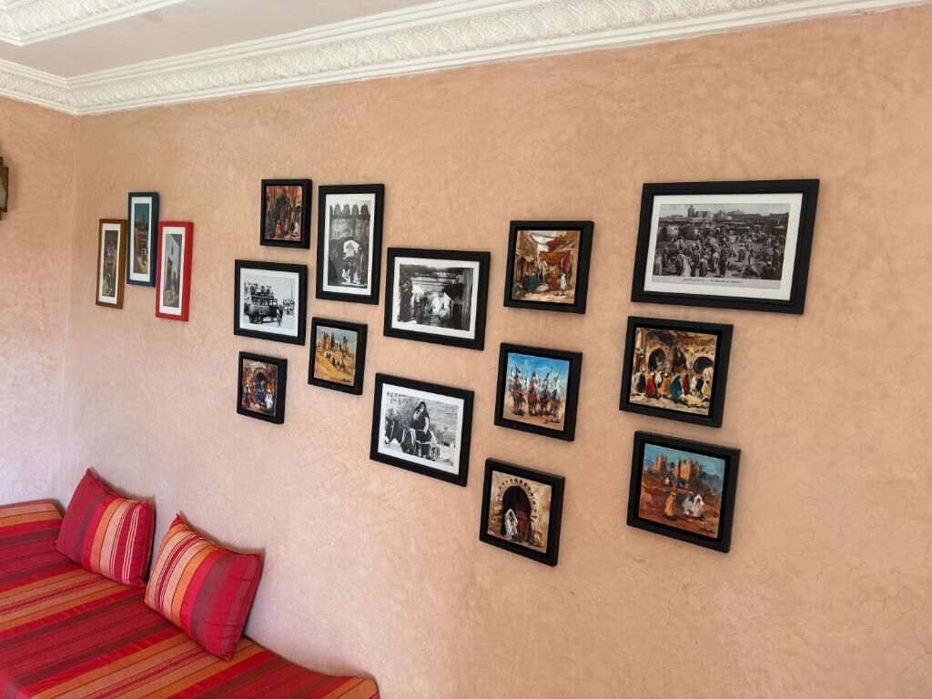 En væg med flere indrammede fotografier arrangeret i et gittermønster.