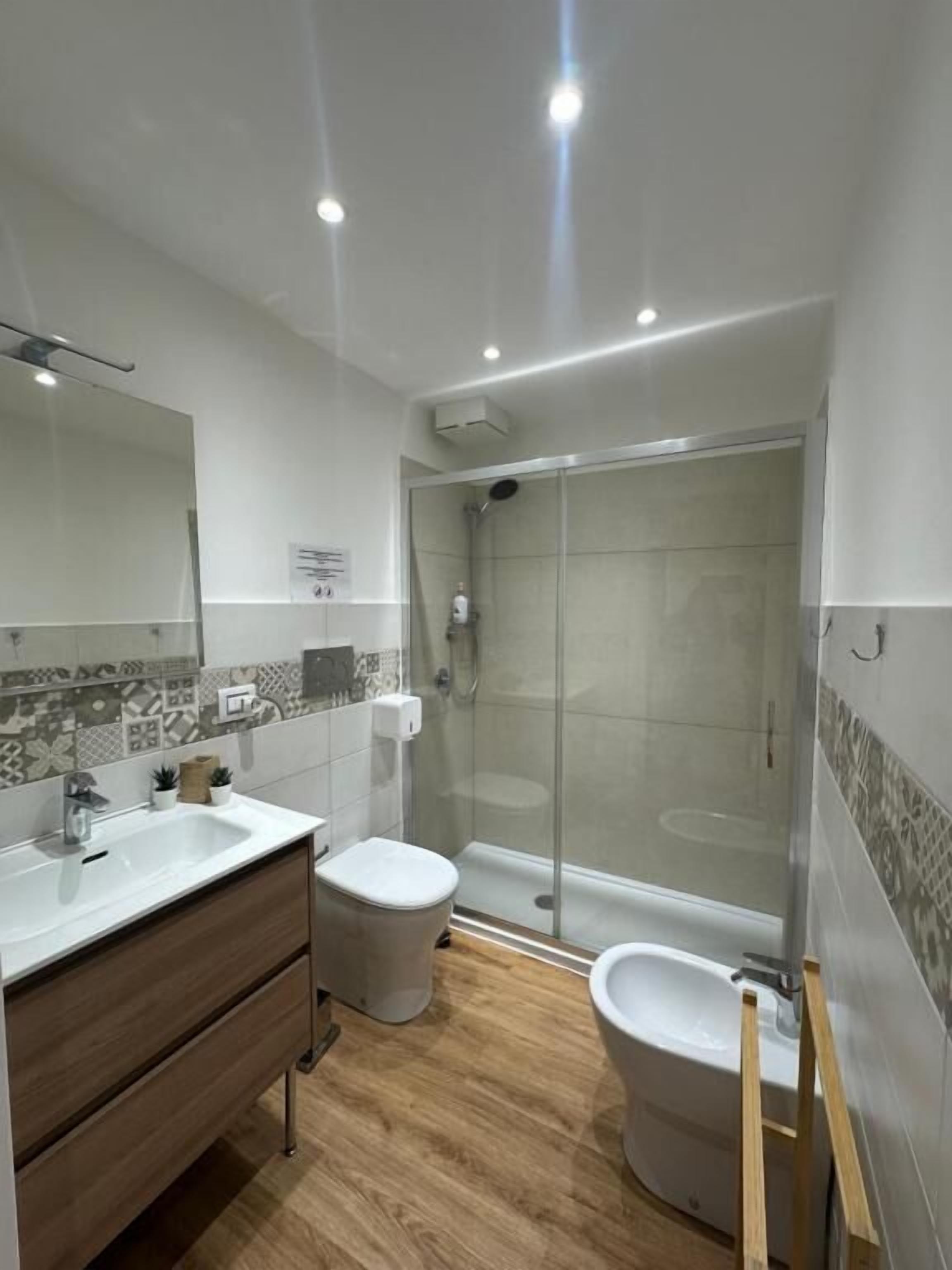A modern bathroom with a shower, toilet, and vanity.