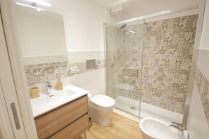 A modern bathroom with a shower, toilet, and sink. - Etna Vibes Home (Catania)