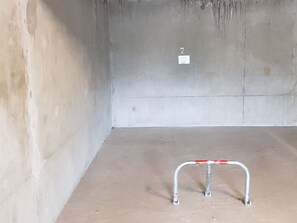 A room with a concrete floor, a metal railing, and a small white sign with the number 7. - 2-room apartment, parking - 4 guests (Valloire)