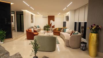 Una sala de estar moderna con un sofá modular, una mesa de centro y un ventanal con cortinas.