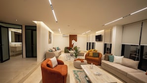 A modern living room with a sofa, armchairs, and a coffee table.