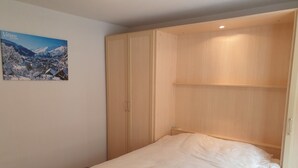 Un dormitorio con cama, armario y un cartel en la pared.