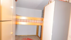A bunk bed with a wooden frame and a mattress with a red design. - Comfortable studio, pets welcome - 4 guests (Valloire)
