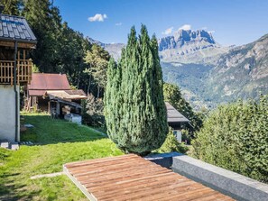 Une terrasse en bois offrant une vue sur une chaîne de montagnes.