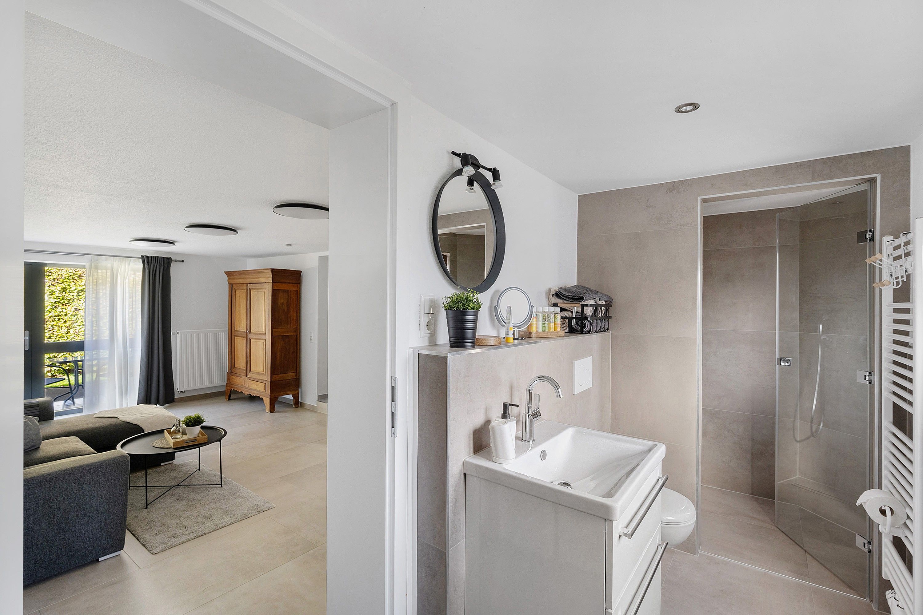 Ein modernes Badezimmer mit Dusche, Waschbecken und Spiegel.