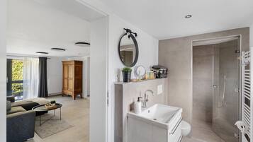 Ein modernes Badezimmer mit Dusche, Waschbecken und Spiegel.