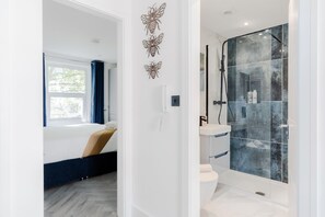 Comfort appartement | Badkamer | Een douche, een haardroger, handdoeken, zeep