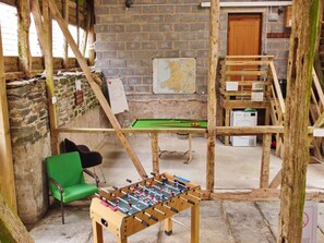 A room with a foosball table, a green chair, and a billiards table. - Sea View Carbis Bay House for 6 (Llandrindod Wells)