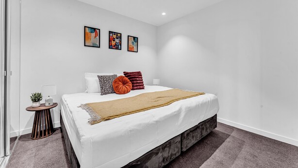 A modern bedroom with a large bed, white walls, and three framed artworks above it. - Platinum Luxe Retreat 2B2B Southbank with Balcony (Southbank)