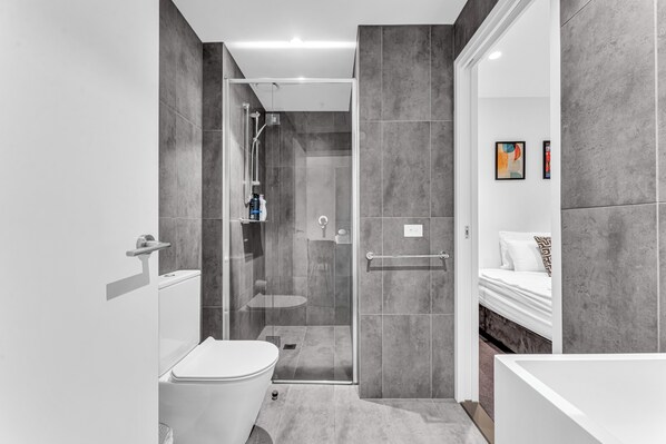A modern bathroom with a glass-enclosed shower, a toilet, and a bathtub. - Platinum Luxe Retreat 2B2B Southbank with Balcony (Southbank)