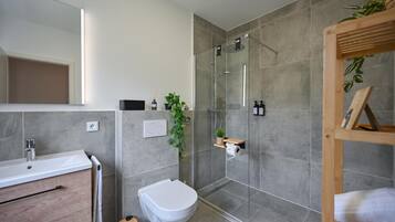 Ein modernes Badezimmer mit Dusche, Toilette und Waschbecken.