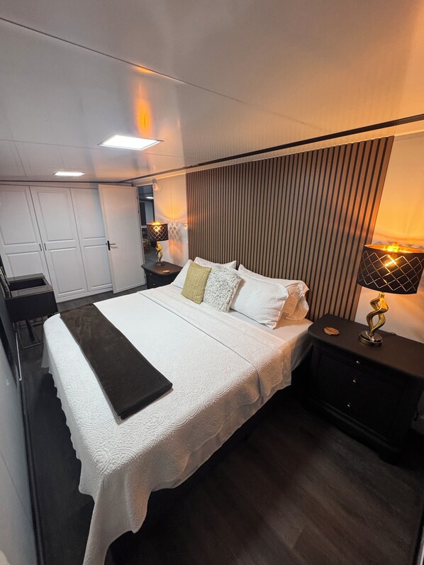 A modern bedroom with a large bed, bedside tables, and a wardrobe. - LA CASITA – Unique Modern Container Home with AC in Sunny Tampa (Tampa)