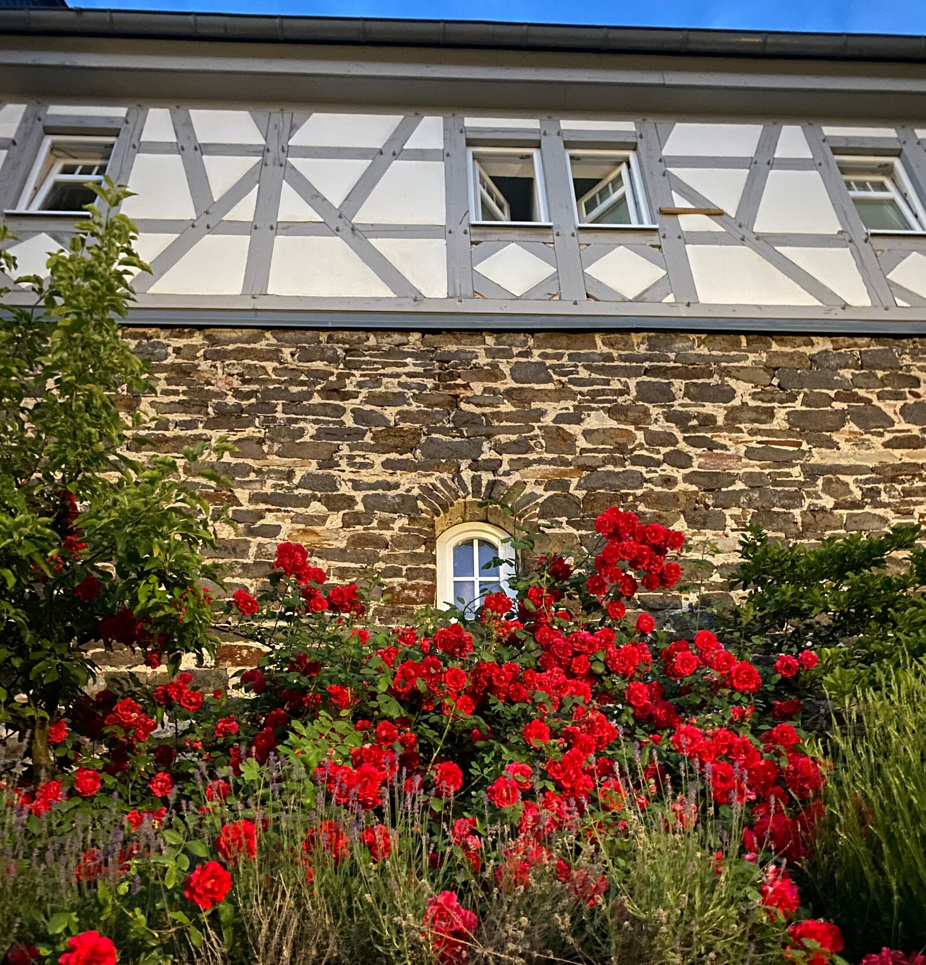 Un bâtiment à pans de bois, doté d’un mur en pierre et d’une fenêtre.