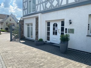 Ein Gebäude mit weißer Fassade, rustikalem Steinunterbau und einem ehrfurchtgebietenden Eingangstor.