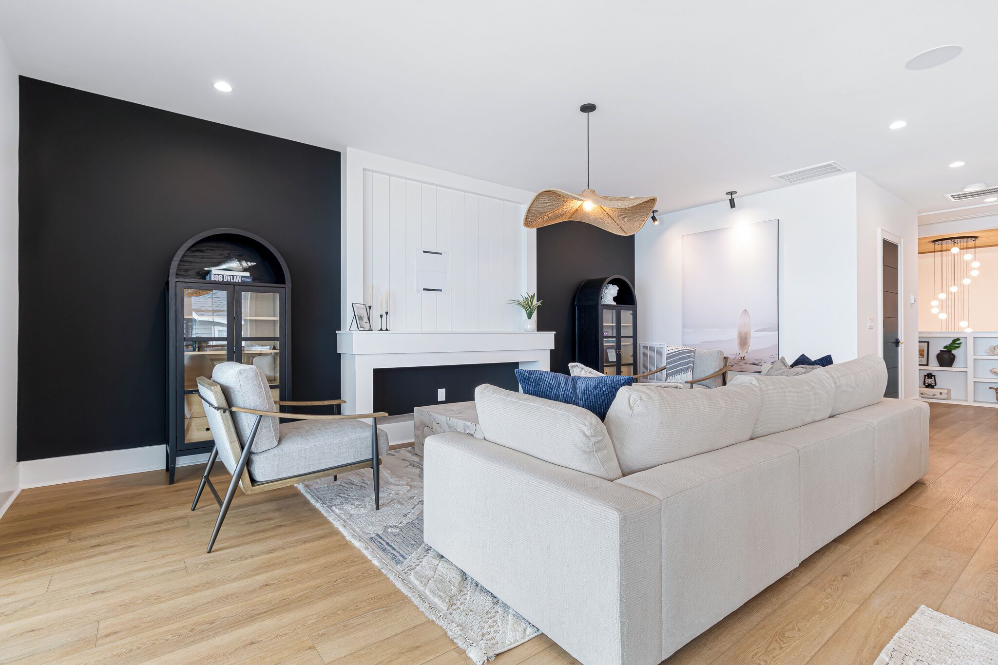 Ein modernes Wohnzimmer mit einer Couch, einem Sessel und einem Kamin.