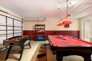 A room with a foosball table, a pool table, and a shelf with items. - Calabay Charm 4 Bedroom Home (Davenport)