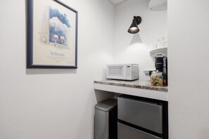 A kitchenette with a microwave, coffee maker, and a framed poster on the wall. - The Nook 1 Bedroom Studio (Telluride)