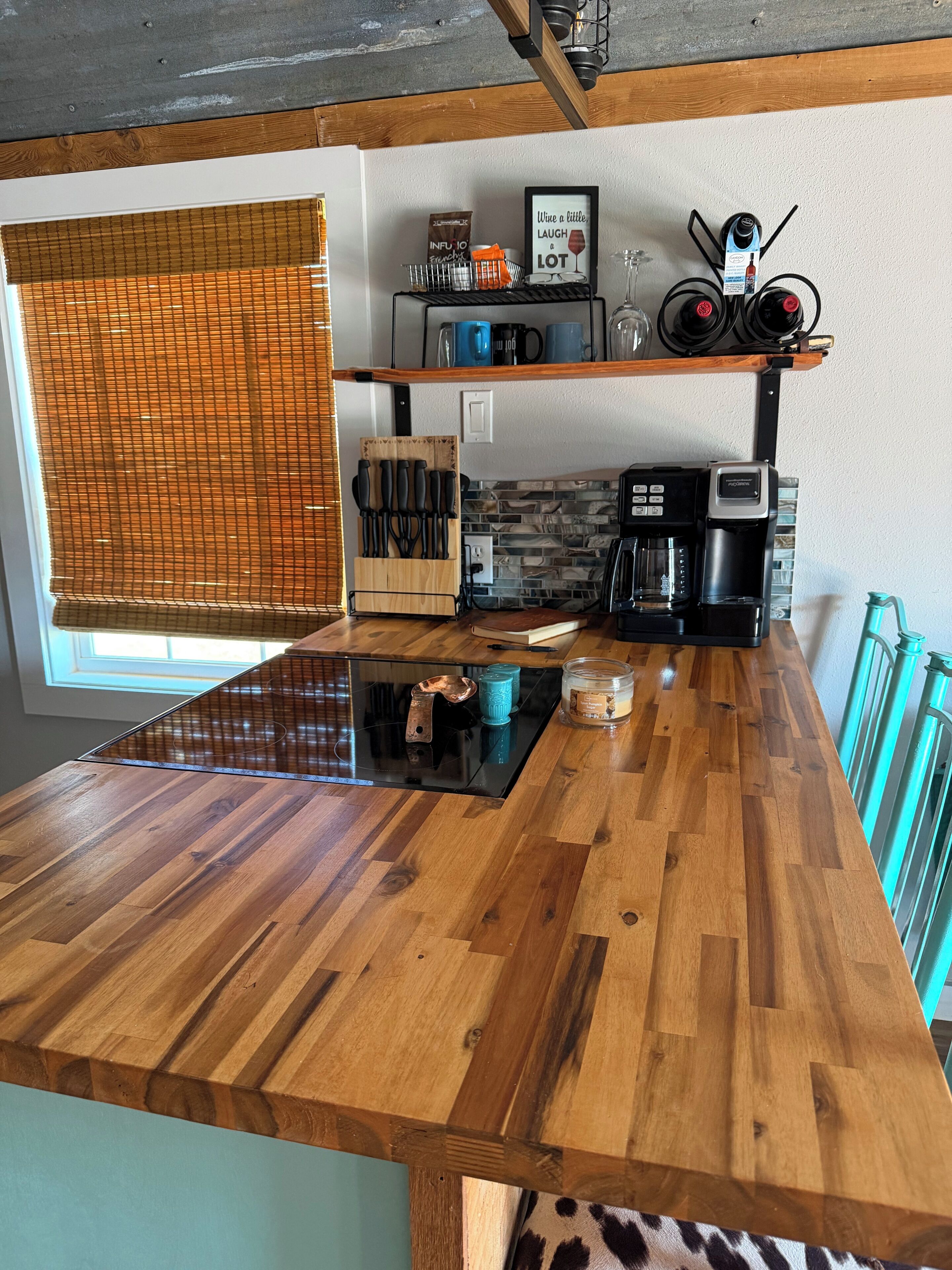 A kitchen with a wooden countertop, a coffee maker, and a knife block.