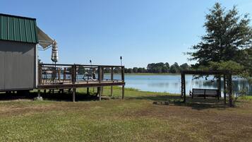 A lakeside deck with outdoor seating and a gazebo.