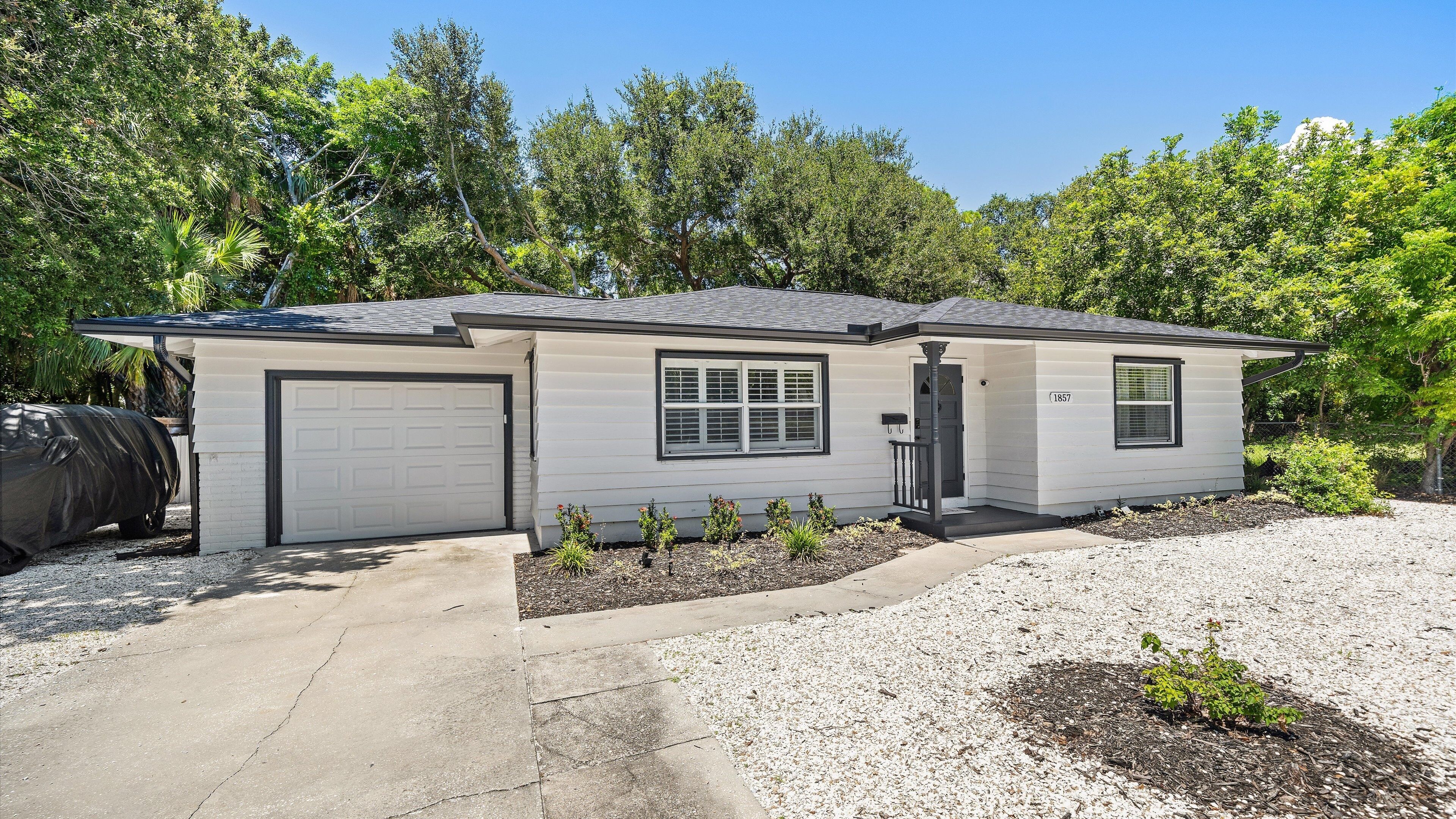 A single-story house with a garage, a covered patio area, and a driveway.