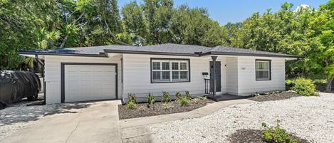 A single-story house with a garage, a covered patio area, and a driveway.
