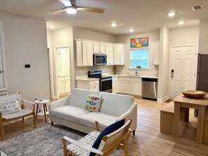 A modern kitchen with white cabinets, a microwave, and a stainless steel refrigerator. - SunFish - 4-bedroom home in gorgeous Port St. Joe with private in-law suite (Port St. Joe)