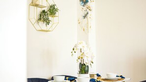 A dining table set with white plates, gold cutlery, and a vase with white flowers. - Stylish 2BR House/Garden/Free Parking/Alton Towers (Stoke-on-Trent)