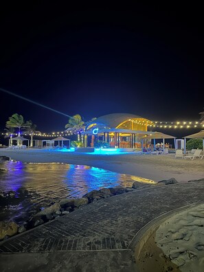A beachfront property with a pool, outdoor seating, and a building with a dome-shaped roof. - NEW! Caribbean Serenity- Villa Marina Apartment (Maria Chiquita)