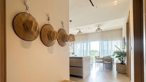 A modern interior with a bench, wall-mounted hats, a kitchen area, and a dining space. - NEW! Caribbean Serenity- Villa Marina Apartment (Maria Chiquita)