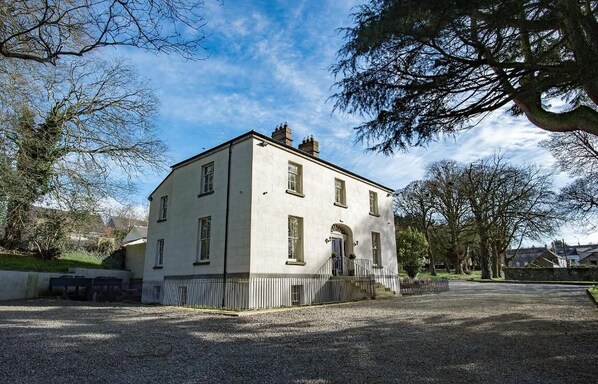 A two-story building with a symmetrical facade, a central entrance with a door, and a small porch area. - Boyne House Slane (Meath)