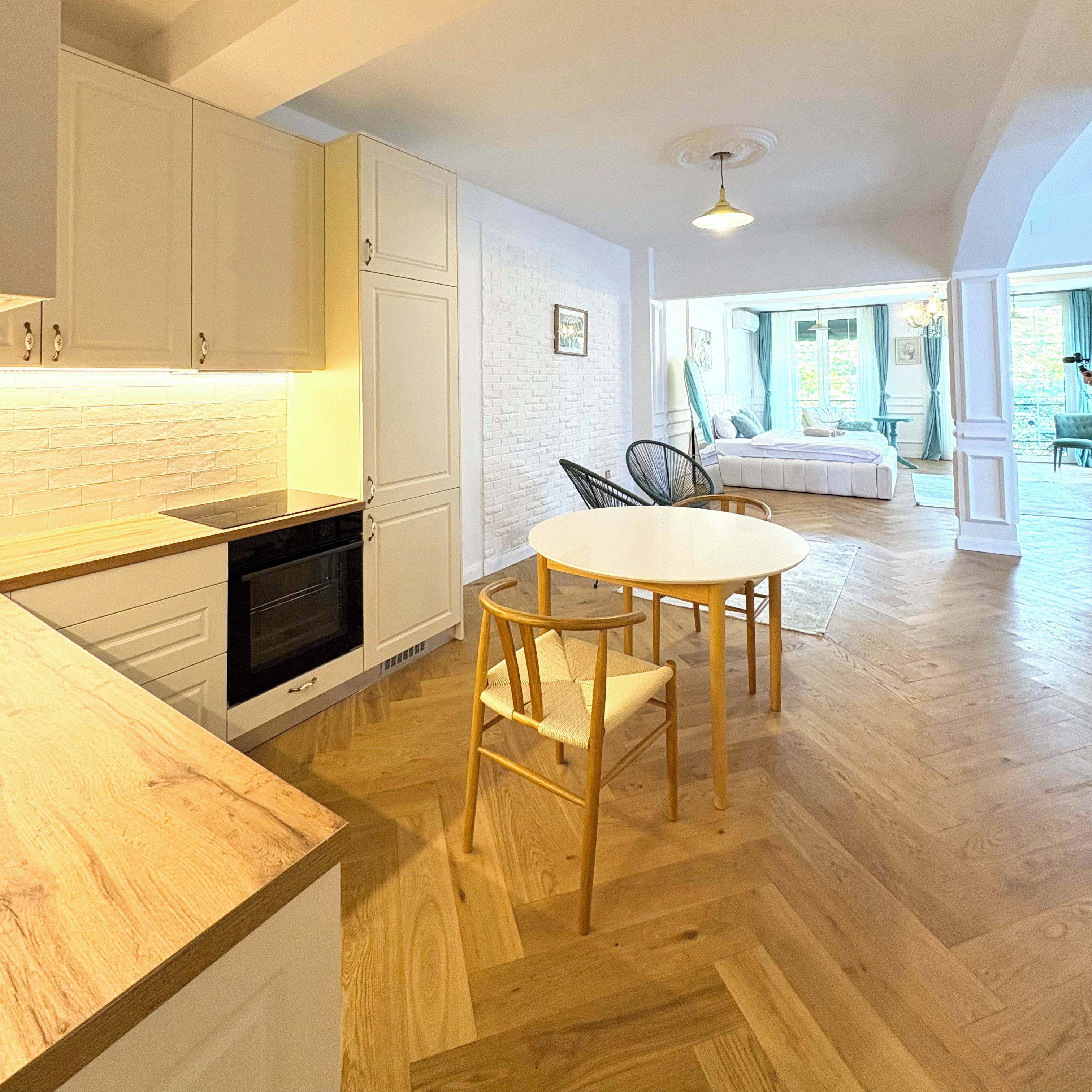 Una cocina moderna con armarios de madera y un comedor con una mesa redonda y sillas.