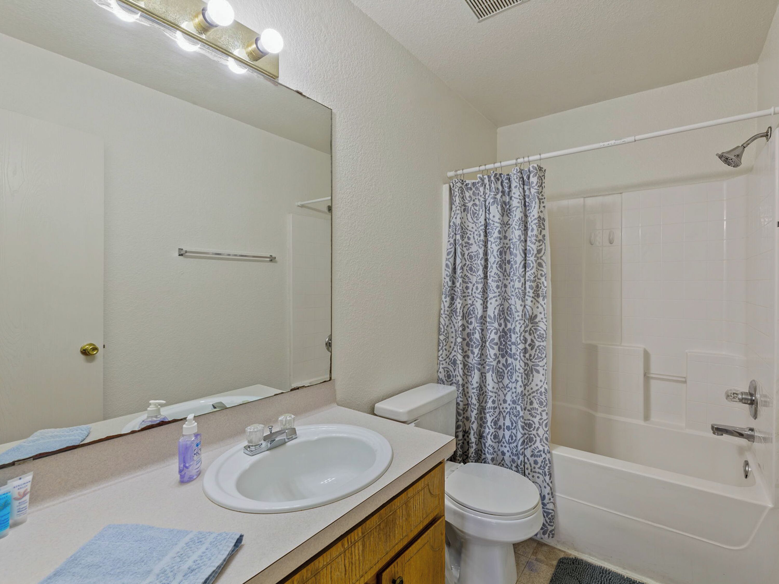 A bathroom with a sink, toilet, and shower.