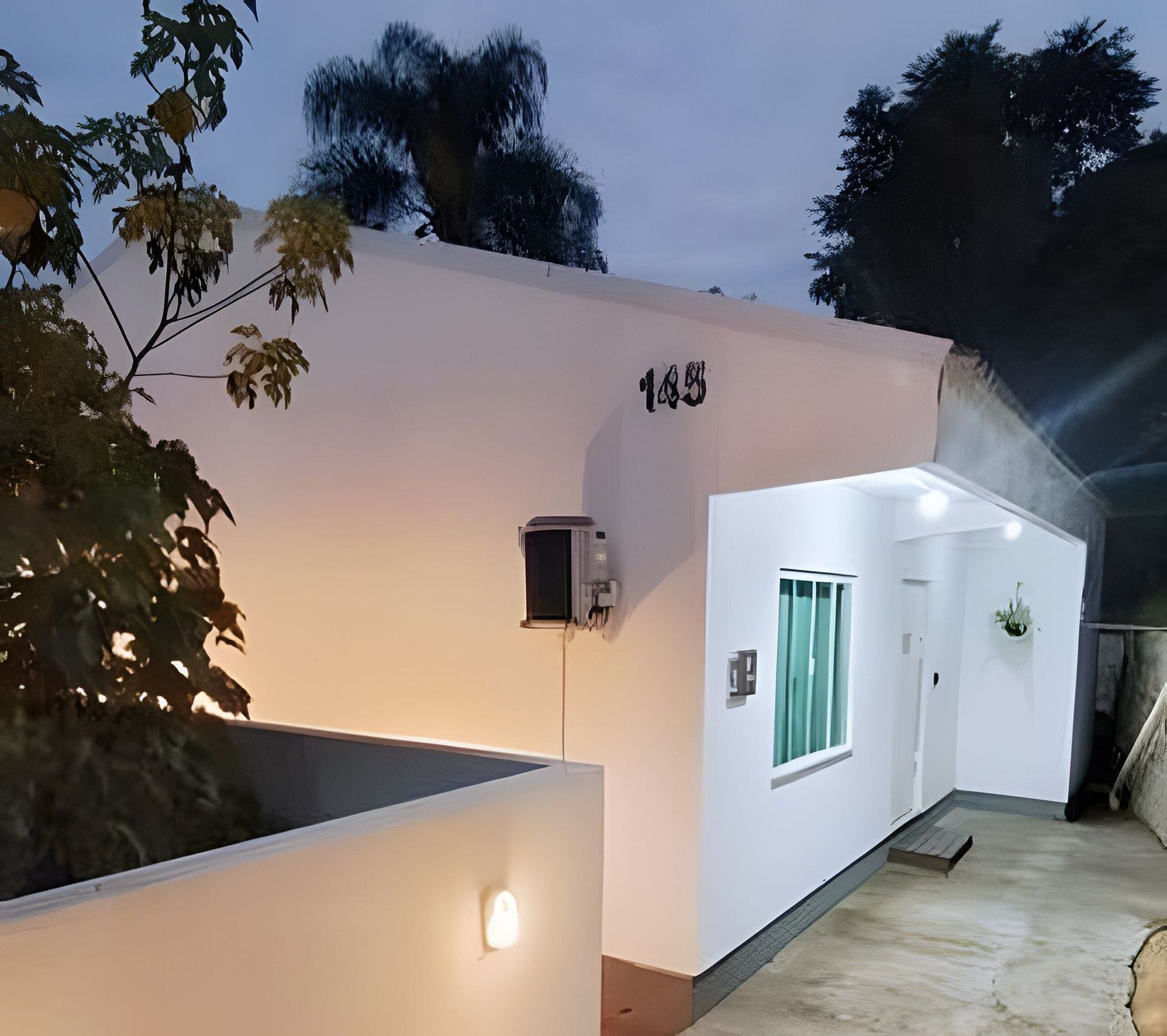 A modern building with a flat facade, a visible number '189', a small window, and a door.