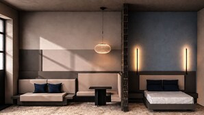 A modern bedroom with a sofa, a small table, a bed, and a hanging light fixture.