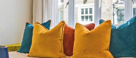 Cama com vários travesseiros em cores variadas.