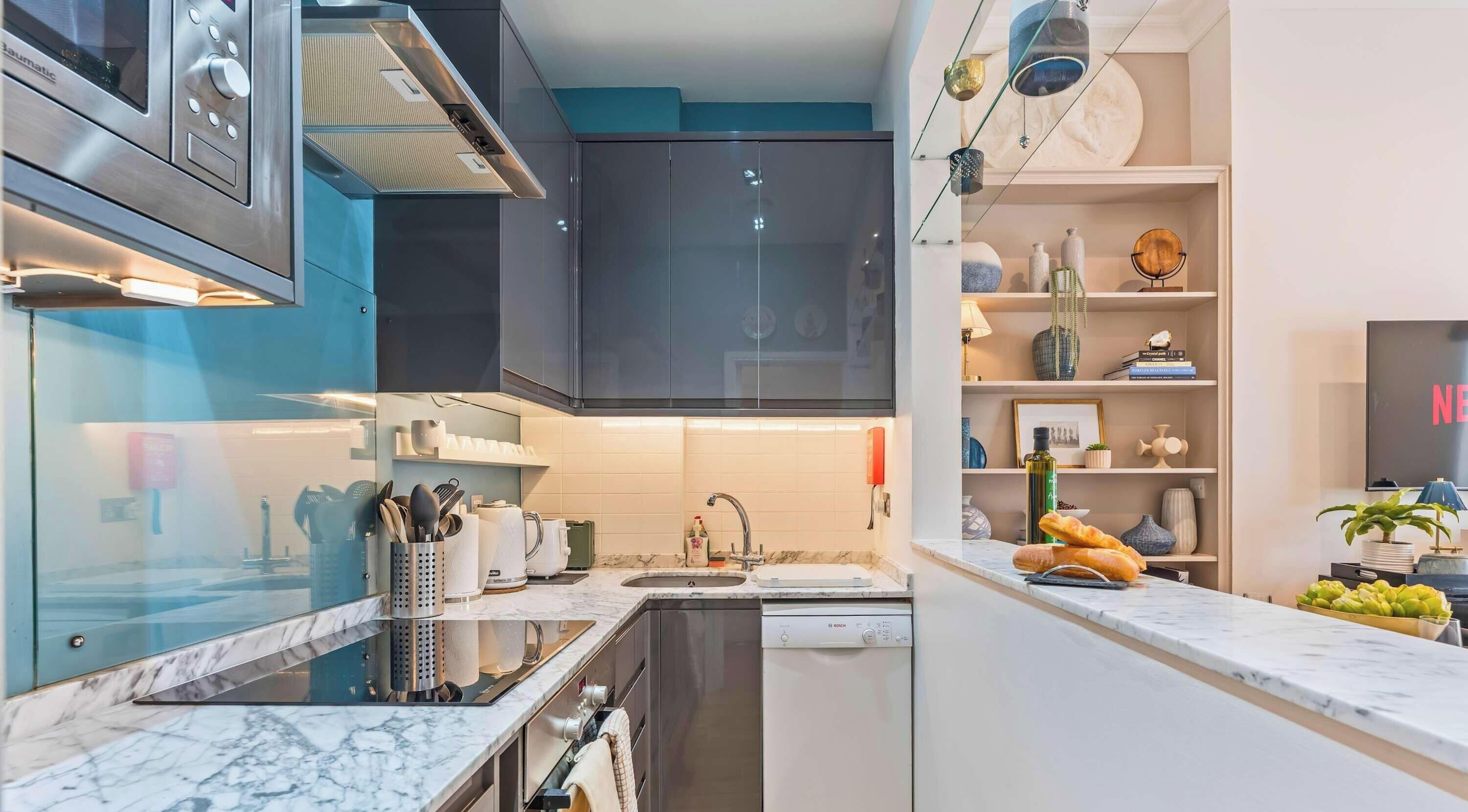 A modern kitchen with a Bosch dishwasher, a built-in oven, and a stainless steel range hood.