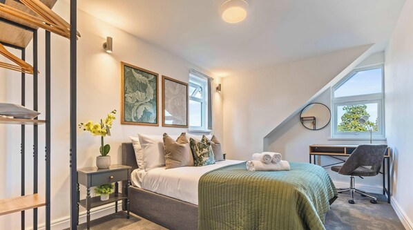 A bedroom with a bed, a desk, a chair, a window, and artwork on the wall. - Spacious Slough House w/ Free Parking & Fast WiFi (Slough)