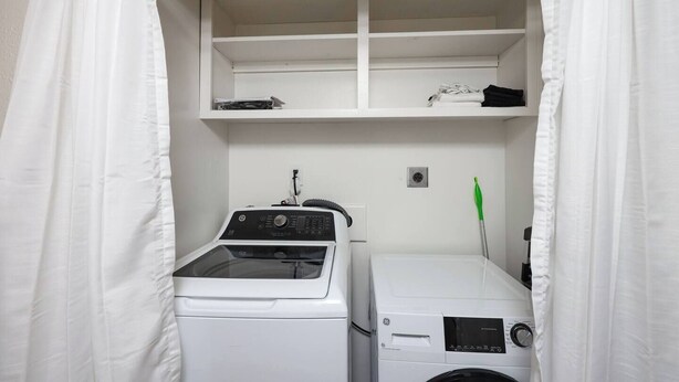 A laundry room with a washing machine, dryer, and shelves above. - 6BR SDSU - Pool & Spa - Poker/Game Rm - Sleep 20+ (San Diego)