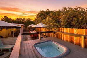 A deck with a hot tub, outdoor seating, and umbrellas. - SDSU Splash Royale 6BR| 12 Bed | Pool&Spa | GameRm (San Diego)
