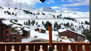 A snowy mountain landscape with ski slopes, a ski lift, and buildings with snow-covered roofs. - Very comfortable apartment in Belle-Plagne, 50 m² (La Plagne Tarentaise)