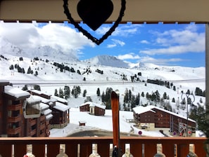 A snowy mountain landscape with ski slopes, a ski lift, and buildings with snow-covered roofs. - Very comfortable apartment in Belle-Plagne, 50 m² (La Plagne Tarentaise)