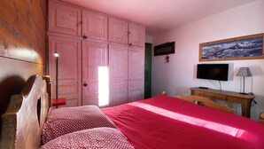 A bedroom with a bed, a wooden wardrobe, a television, and a desk. - Very comfortable apartment in Belle-Plagne, 50 m² (La Plagne Tarentaise)