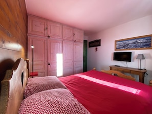 A bedroom with a bed, a wooden wardrobe, a television, and a desk. - Very comfortable apartment in Belle-Plagne, 50 m² (La Plagne Tarentaise)