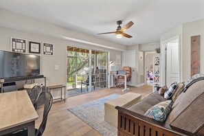 A spacious living area with a television, a dining table, a sofa, and a ceiling fan. - Waterfront 4BR/2.5BA home with direct access to the Clermont Chain of Lakes! Private dock with boat slips & 1 motorized lift — perfect for boating & kayaking.  Gourmet kitchen, luxurious primary suite, available kayaks onsite. (Clermont)